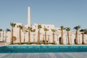 a row of palm trees in front of a building at Alvino Relais Mulino Contemporaneo in Matera