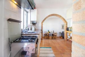 a kitchen with a stove and a dining room at Casa Oceano-Ave do Mar in Raposeira