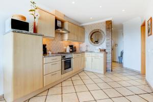 una cucina con armadietti bianchi e pavimento piastrellato di Casa D'Luz a Carvoeiro