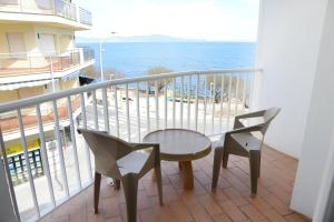 a balcony with a table and two chairs and the ocean at Rallye Hotel in L'Escala