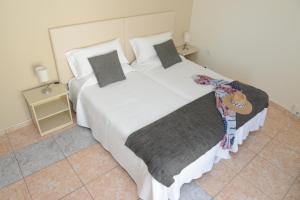 a bedroom with a large bed with white sheets and pillows at Rallye Hotel in L'Escala