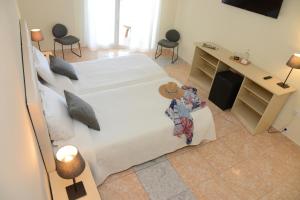 a bedroom with a large bed with a desk and chairs at Rallye Hotel in L'Escala