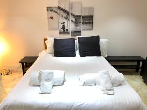 a large white bed with three pillows on it at MyCityHaven South Parade Mansions in Bristol