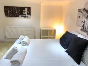 a bedroom with a large white bed with towels on it at MyCityHaven South Parade Mansions in Bristol