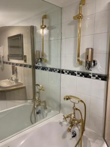 bagno con vasca, lavandino e specchio di MyCityHaven South Parade Mansions a Bristol