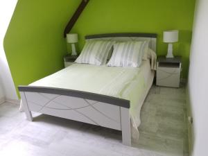 a bedroom with a large bed with green walls at Chez Marie in Dol-de-Bretagne