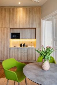 a dining room with a table and green chairs at Lakeside Budapest Residences in Budapest