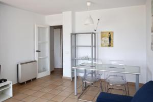 een eetkamer met een glazen tafel en stoelen bij AT038 Vistas de la playa, primera línea con piscina in Torredembarra