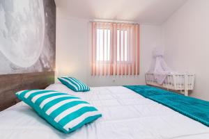 a bedroom with two beds with blue and white pillows at Selina Ferienwohnung in Loborika