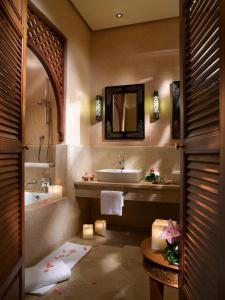 La salle de bains est pourvue d'un lavabo, d'une baignoire et d'un miroir. dans l'établissement Golf Club Rotana Palmeraie, à Marrakech