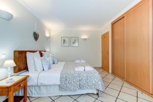 una camera con un grande letto e un armadio in legno di Casa D'Luz a Carvoeiro