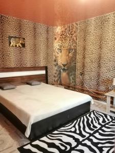 1 dormitorio con 1 cama y un mural de un tigre en Always at home - Apartments at Klimasenko 11 block 7, en Novokuznetsk