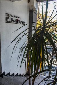 a sign on the side of a building with a plant at Edificio Mitre in Maipú