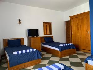 a hotel room with two beds and a tv at Sea Soul Hotel in Dahab