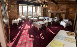 a restaurant with white tables and chairs in a room at Ye Olde White Harte Hotel in Burnham-on-Crouch