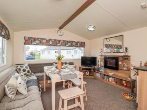 ein Wohnzimmer mit einem Sofa und einem Tisch in der Unterkunft Moonstone Lodge in Dover