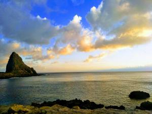 an island in the ocean with a cloudy sky at 蘭嶼小島觀海旅宿 in Lanyu