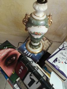 eine Vase, die auf einem Haufen Bücher liegt in der Unterkunft Casa Segota in Veli Iž