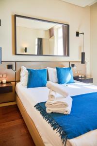 a bedroom with two beds with blue pillows and a mirror at Lisbon Five Stars Apartments 8 Building in Lisbon