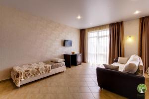 a bedroom with a bed and a couch in a room at Hotel Laura in Lazarevskoye