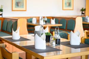 a table in a restaurant with tables and chairs at Hotel Olympia Schießanlage in Garching bei München