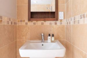 y baño con lavabo blanco y espejo. en Montpellier Apartment- The Heart of Harrogate Town Centre- One minute walk from the Famous Betty's Tea room extremely quiet entire apartment with homely living room huge TV and sound bar with a huge comfy Super King size beds sleeps four, en Harrogate