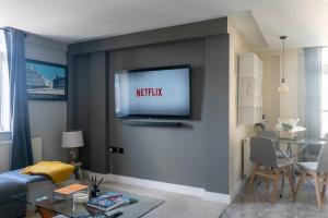 TV a/nebo společenská místnost v ubytování Montpellier Apartment- The Heart of Harrogate Town Centre- One minute walk from the Famous Betty's Tea room extremely quiet entire apartment with homely living room huge TV and sound bar with a huge comfy Super King size beds sleeps four