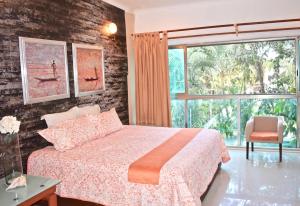 sypialnia z łóżkiem i dużym oknem w obiekcie Casa la Selva w mieście Cancún