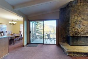 un soggiorno con camino in pietra e una sala da pranzo di Lake Cliffe 302 a Dillon