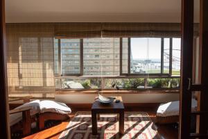a living room with a large window with a view at Apartamento Portas do Mar I in Matosinhos