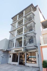a tall white building with fire escapes at OYO 561 Abn Hostel in Bacolod