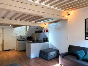 a living room with a kitchen and a couch at LE FOCH in Aix-en-Provence