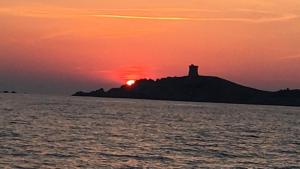 un faro su una collina con il tramonto sullo sfondo di clos des oliviers a Cargèse