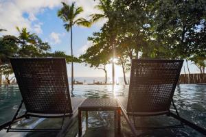 two chairs sitting next to a swimming pool at Kûara Hotel in Arraial d'Ajuda +97 photos