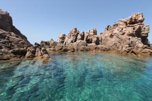 uma piscina de água junto a algumas rochas em Costa Paradiso Resort em Costa Paradiso