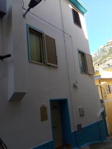 un edificio bianco con porta blu e finestre di Affittacamere S' Eremu a Dorgali