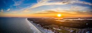 a sunset view of a beach with a city skyline at Days Inn & Suites by Wyndham Jekyll Island in Jekyll Island