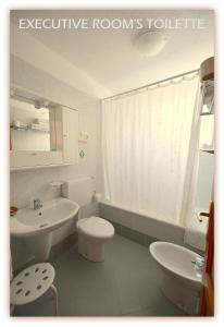 a bathroom with a white toilet and a sink at Hotel Beau Sejour in Etroubles +93 photos