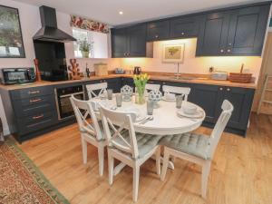 cocina con mesa de comedor blanca y sillas en Todridge Barn, en Newcastle