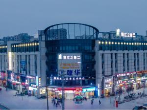 un gran edificio con gente caminando delante de él en Jinjiang Inn Select Qiaosinan Metro Station, Hangzhou en Hangzhou