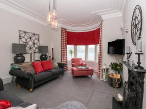 a living room with a couch and a red chair at 1 Craiganrioch in Campbeltown