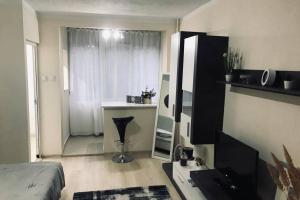 Un dormitorio con una cama y una habitación con ventana. en REEAS APARTAMENT, en Timisoara