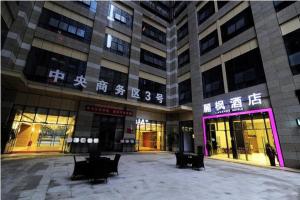 a large building with chairs in front of it at Lavande Hotel Guiyang Huaguoyuan Shopping Mall in Guiyang
