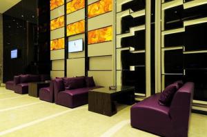 uma sala de estar com sofás roxos e uma mesa em Lavande Hotel Guiyang Huaguoyuan Shopping Mall em Guiyang