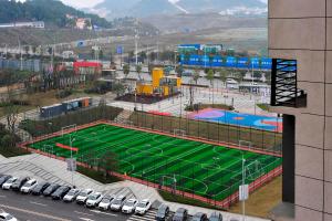 - un terrain de basket dans un parking avec des voitures garées dans l'établissement Lavande Hotels·Guiyaung North Railway Station, à Guiyang