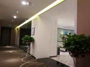 un hall avec des plantes en pot et un mur blanc dans l'établissement Xana Lite Guiyang Flower Orchard Petronas Twin Towers, à Guiyang