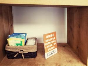 a shelf with a box and a sign in a room at 7Days Premium Guiyang North Station in Guiyang