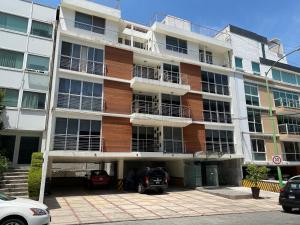 a large building with cars parked in front of it at Grupo Kings Suites - Monte Chimborazo 567 in Mexico City