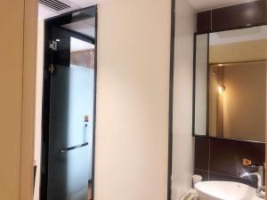 a bathroom with a shower and a sink and a mirror at IU Hotel Guiyang Olympic Sports Center China Resources Vientiane in Guiyang