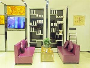 two purple chairs and a table in a living room at Lavande Hotel Guiyang Flower Orchard Fortune Plaza in Guiyang